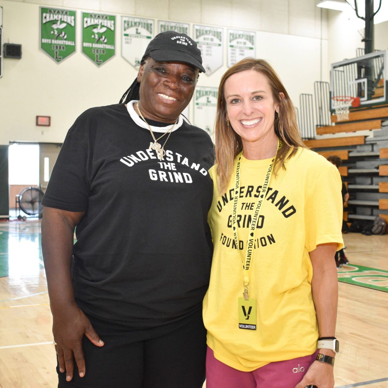 DSC_0240 2 female volunteers smiling on a basketball court